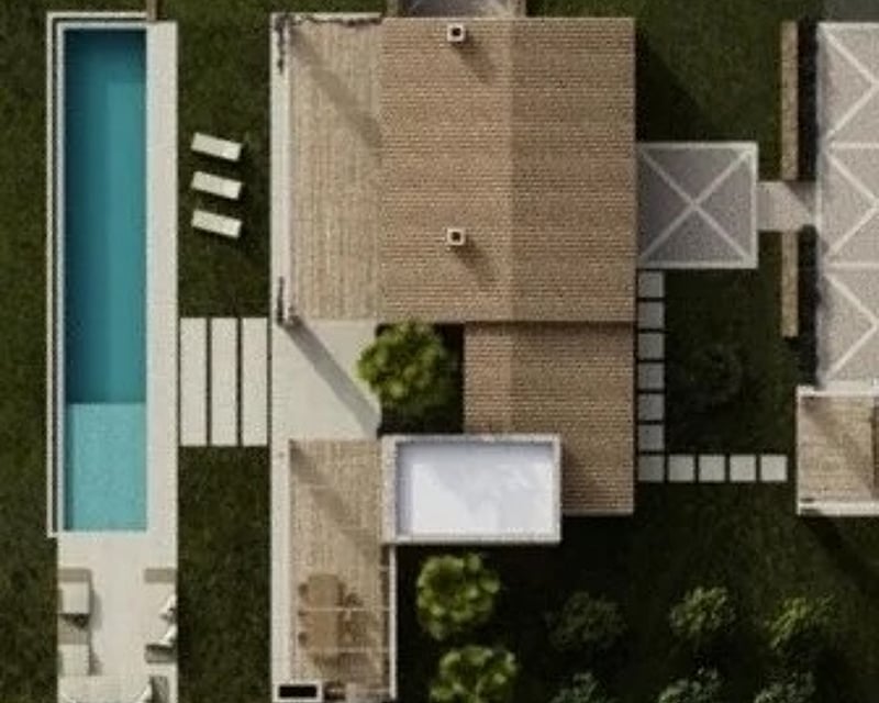 Top-down aerial view of a luxury villa featuring a long turquoise pool, lush green lawn, and stone terraces.
