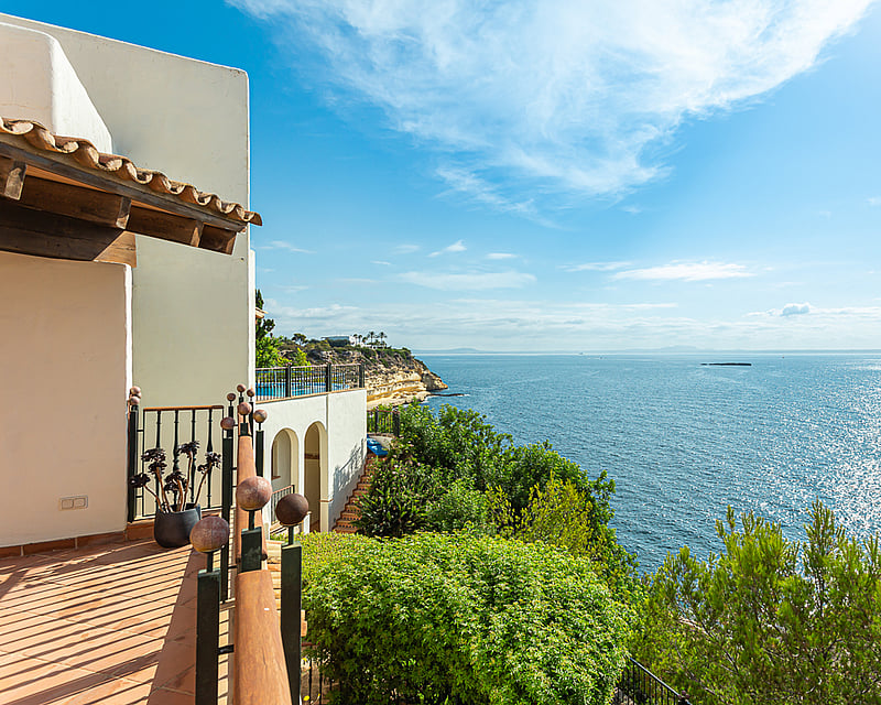 Exterior view of a modern house featuring a pool, lush garden, and large windows illuminating the interior.
