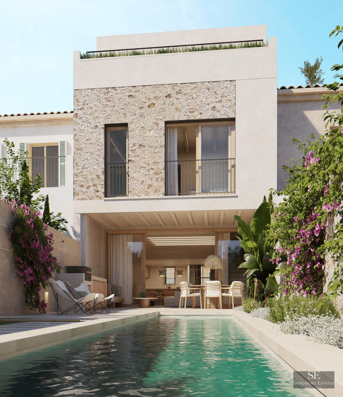 A lap pool in front of a modern white villa with natural stone cladding and vibrant bougainvillea flowers.