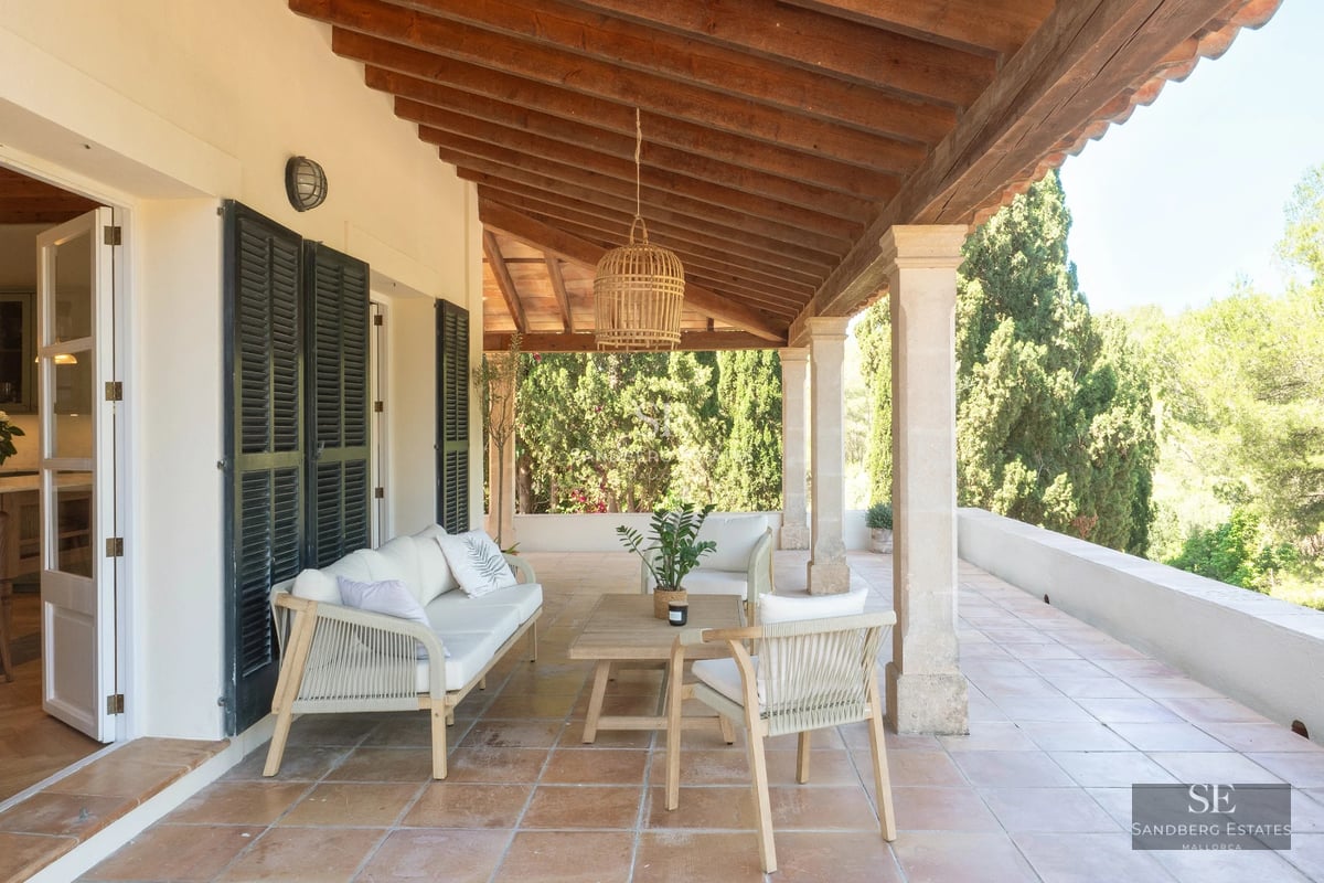 Wide view of a pool bordered by a manicured garden and a modern villa with minimalist design. Natural lighting.
