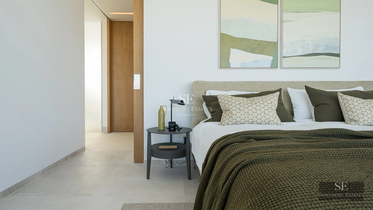 Spacious living room with large windows, modern fireplace, and garden view. Designer furniture and abundant natural light.