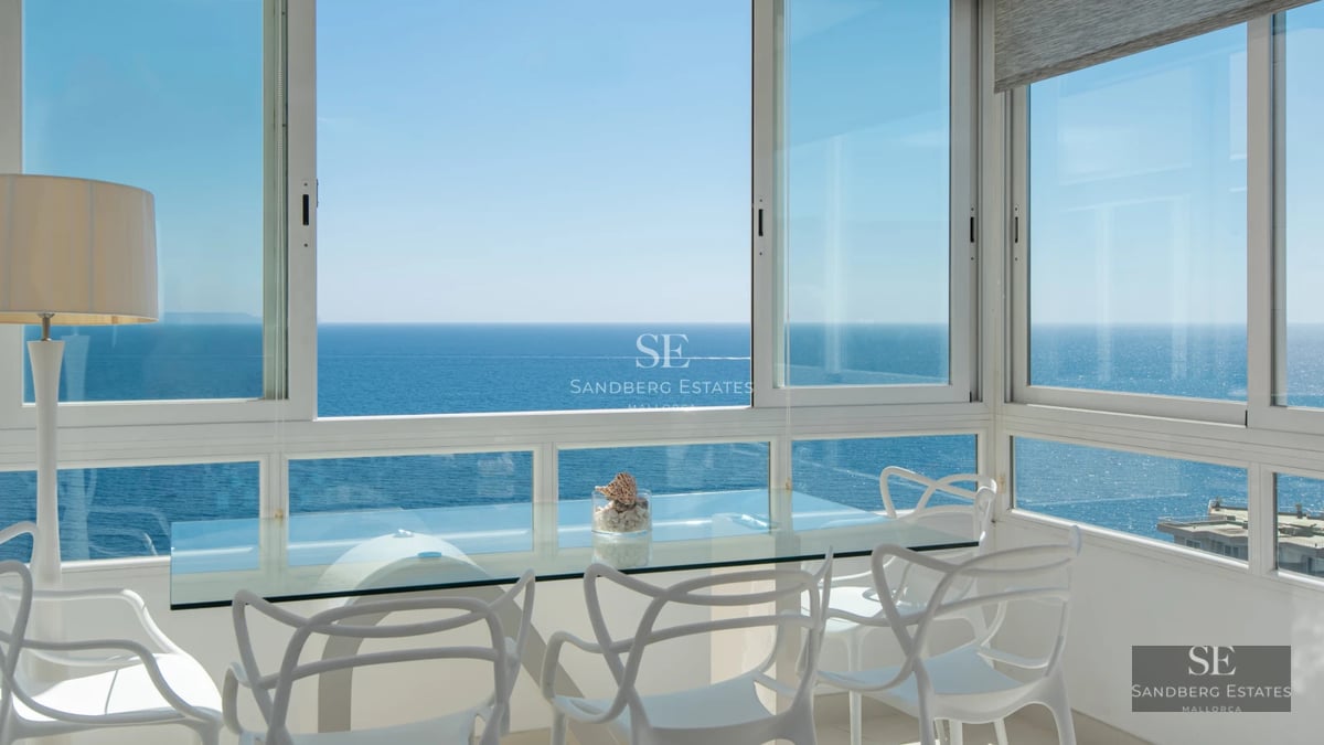 Spacious living room with panoramic windows. Light wood floors, modern fireplace, and designer furniture. Views of greenery.