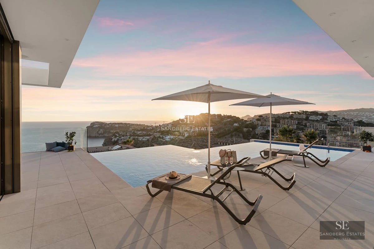 Expansive terrace with infinity pool surrounded by lush garden and modern furniture. Contemporary architecture and panoramic views.