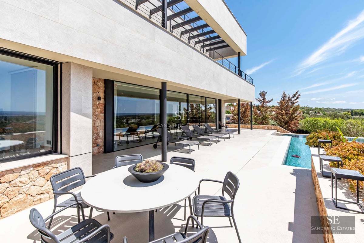 Spacious balcony with sea view. Modern outdoor furniture and glass railing. Bright and open space, ideal for relaxing.