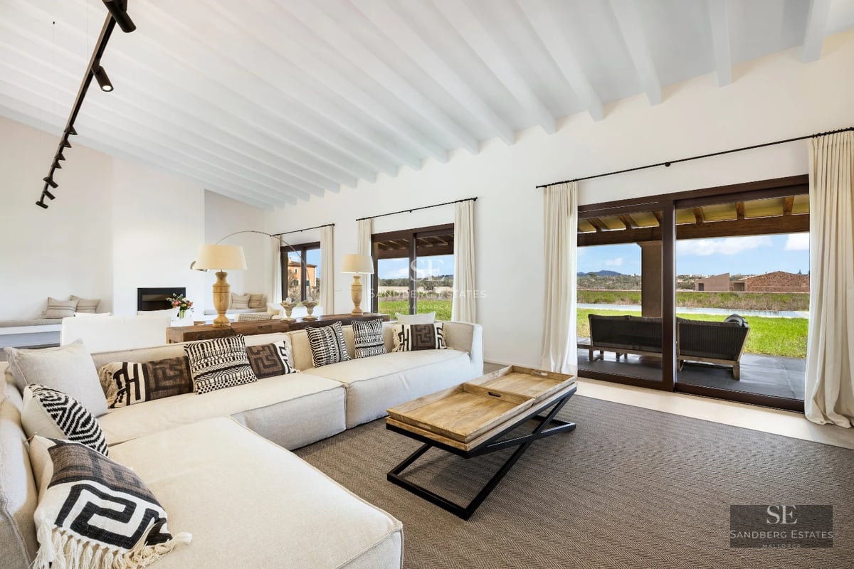 Spacious living room featuring panoramic windows, light wood flooring, and stunning ocean views. Modern and bright design.