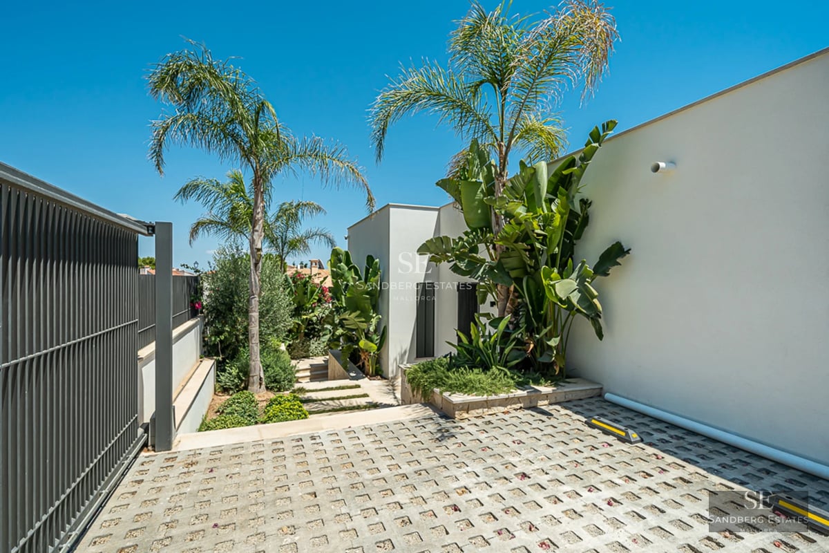 Grande piscine bordée d'une végétation luxuriante. Architecture moderne avec de grandes baies vitrées. Idéal pour la détente et les loisirs en plein air.