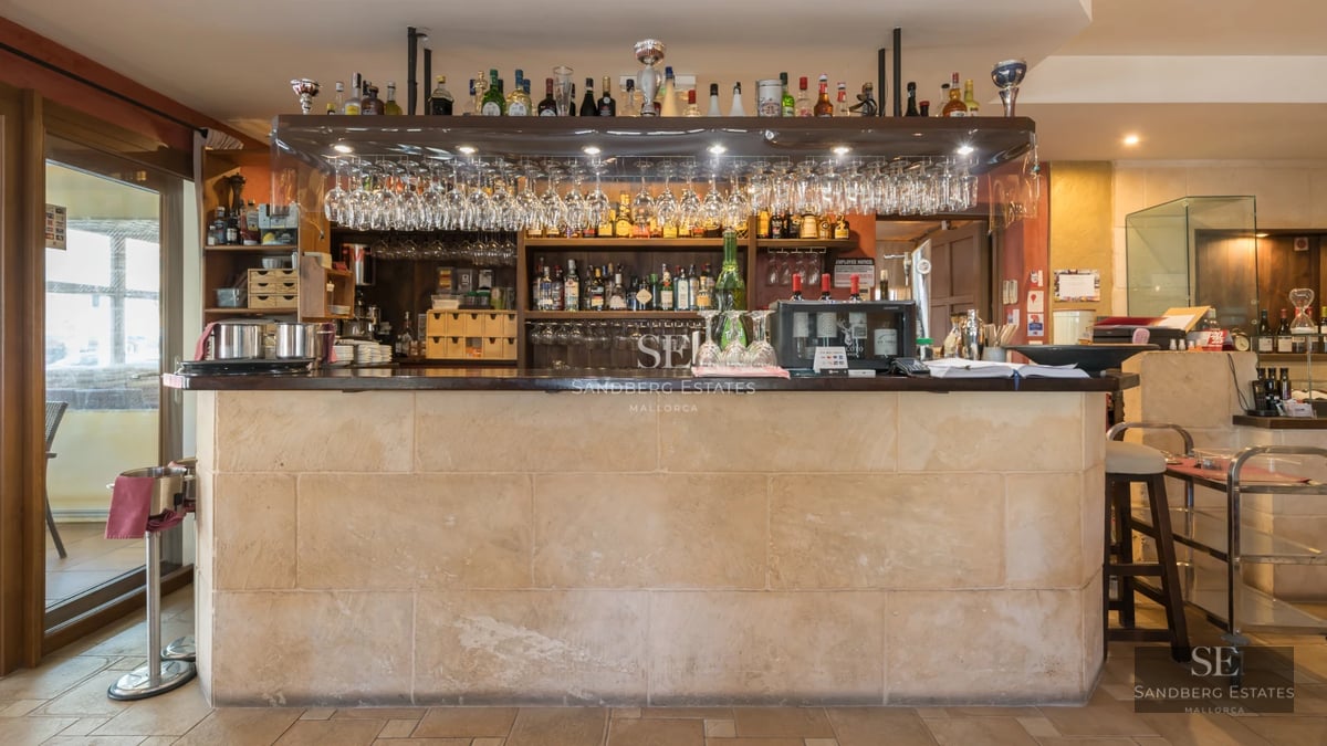 Spacious balcony overlooking the sea and pool. Modern design with glass railing and stylish furniture. Natural lighting and neutral colors.