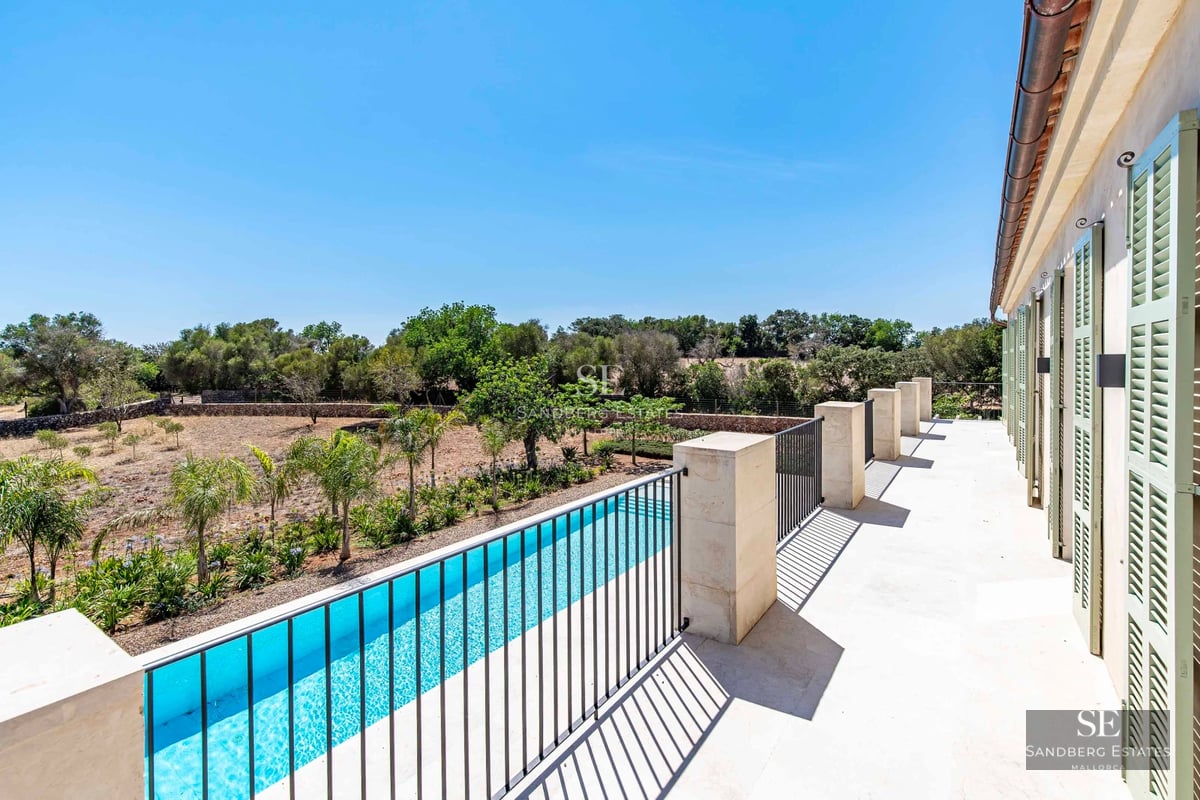 Exterior view of a modern villa with infinity pool, sun loungers and lush greenery. Minimalist architecture with large windows.