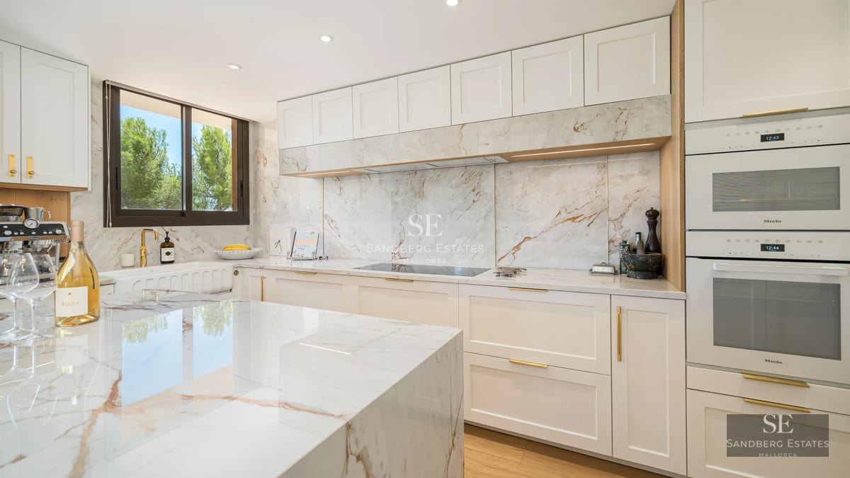 Modern living room with balcony, large windows, light wood floors, and designer furniture. Abundant natural light.