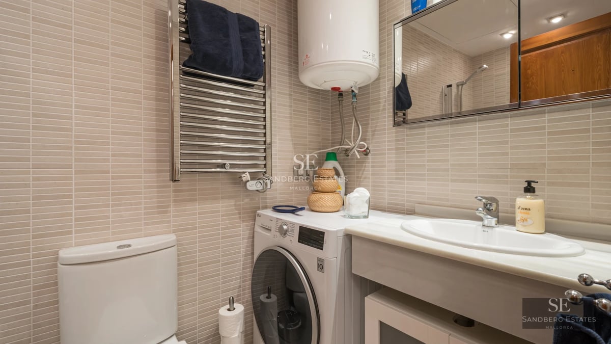 View of a luxurious swimming pool surrounded by lush greenery and a modern house with large windows.