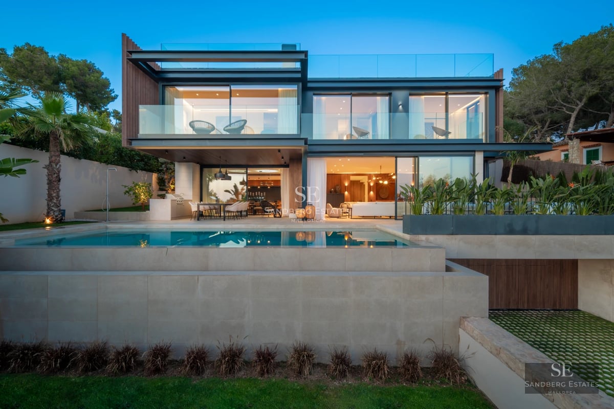 Modern villa exterior with reflective pool, manicured lawn, and minimalist architecture. Soft ambient lighting.