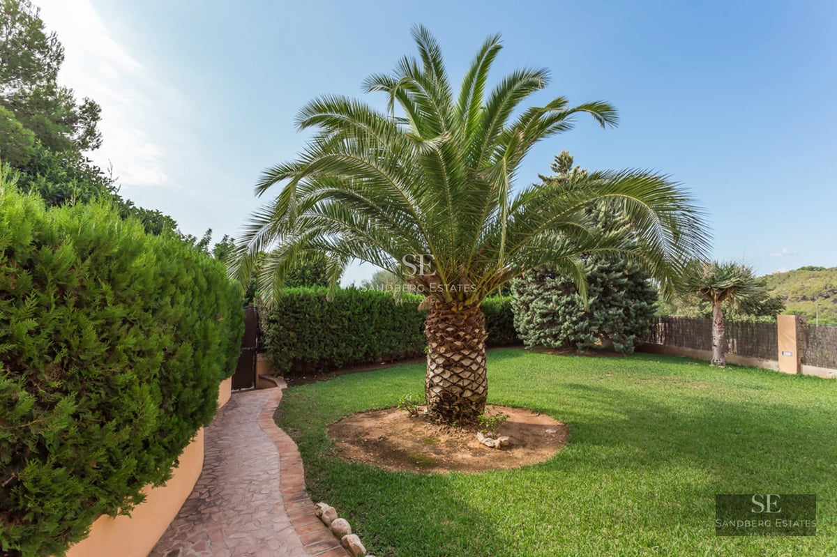 Modern villa view with large terrace, infinity pool, sun loungers, and minimalist outdoor furniture. Well-maintained garden.