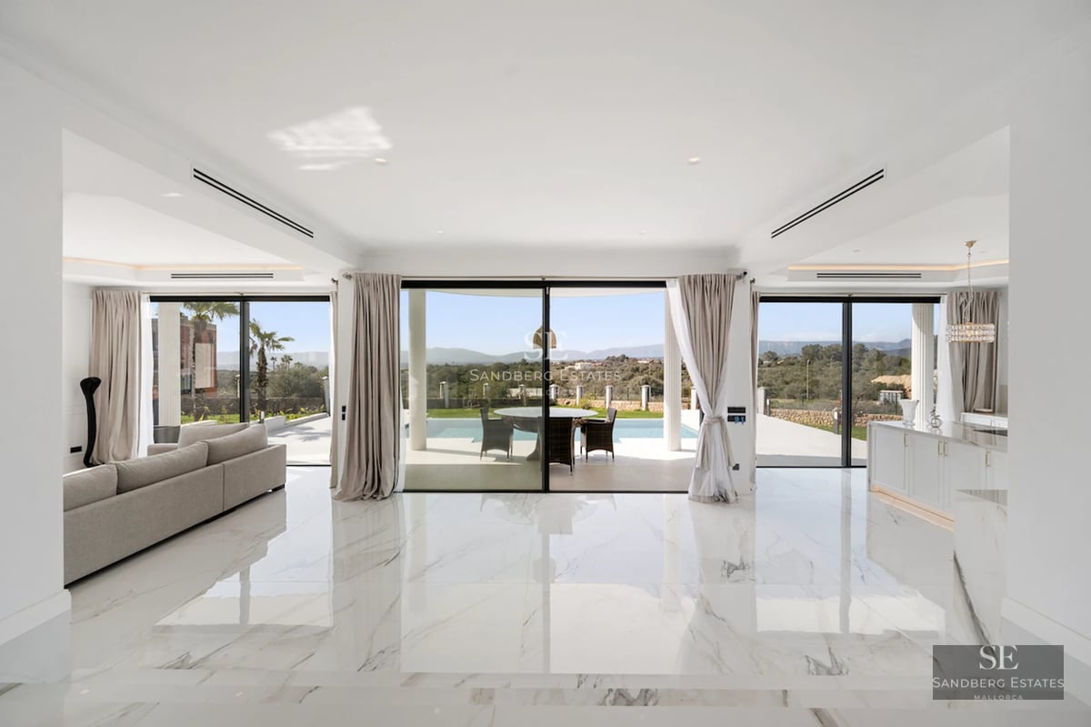 Exterior view of a modern villa featuring an infinity pool, spacious terraces, lush garden, and minimalist architectural design.