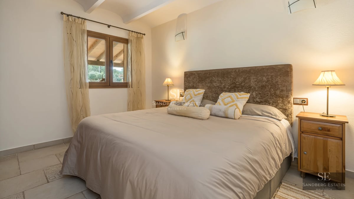 View of an elegant villa featuring an infinity pool, sun loungers, and a manicured garden. Modern architecture with large windows.