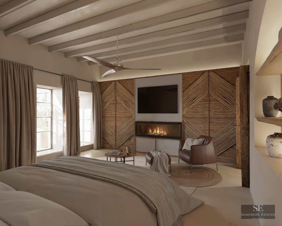 Spacious bedroom with a modern fireplace, leather armchair, wooden beamed ceiling, and a large bed in the foreground.