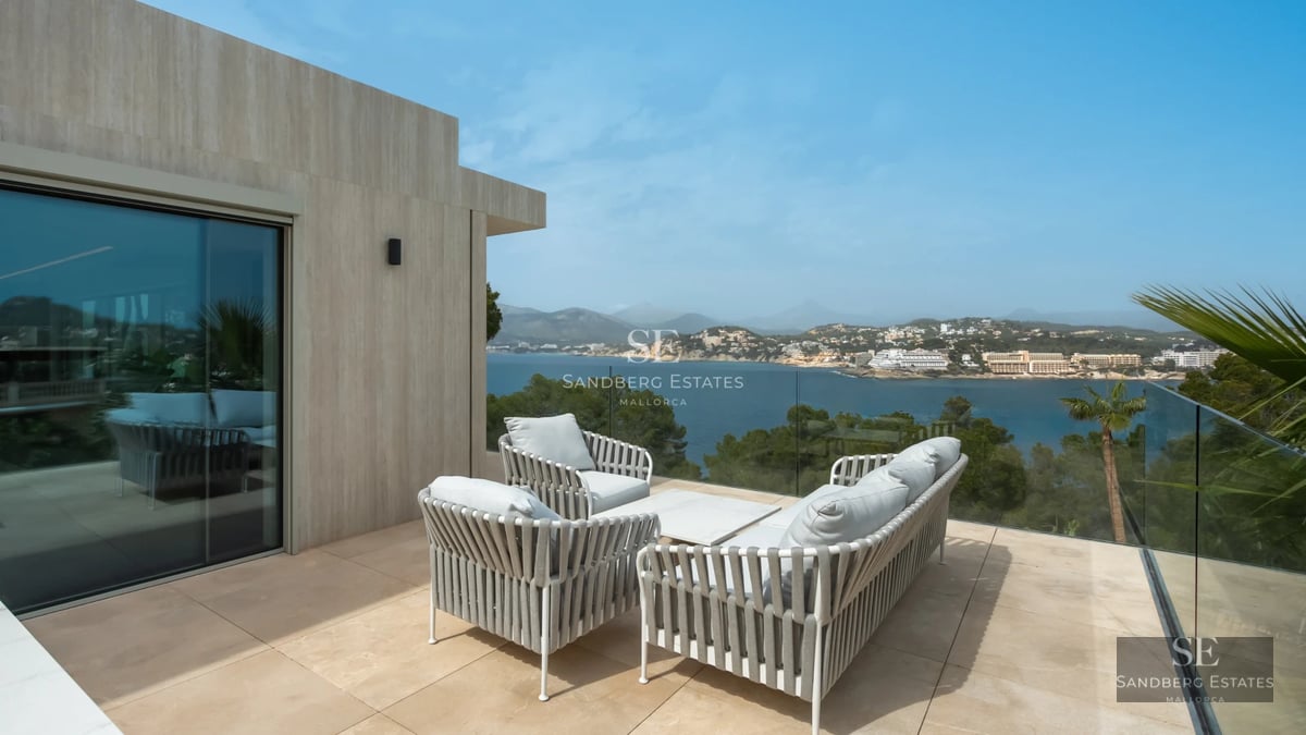 Spacious, bright living room with large windows, modern fireplace, and panoramic views. Designer sofas and elegant decor.