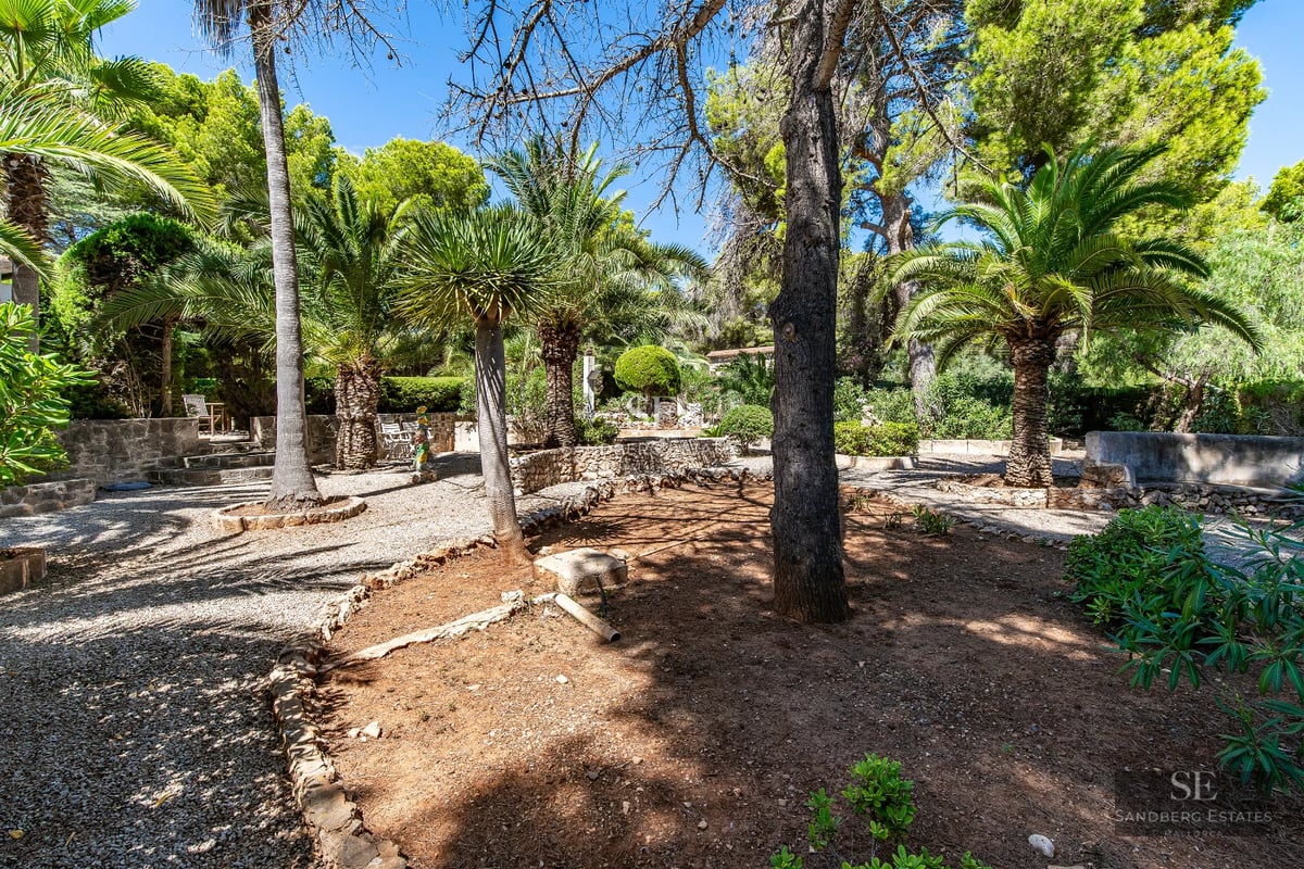 Spacious outdoor area with infinity pool, sun loungers, landscaped garden, and modern architecture. Elegant and relaxing design.