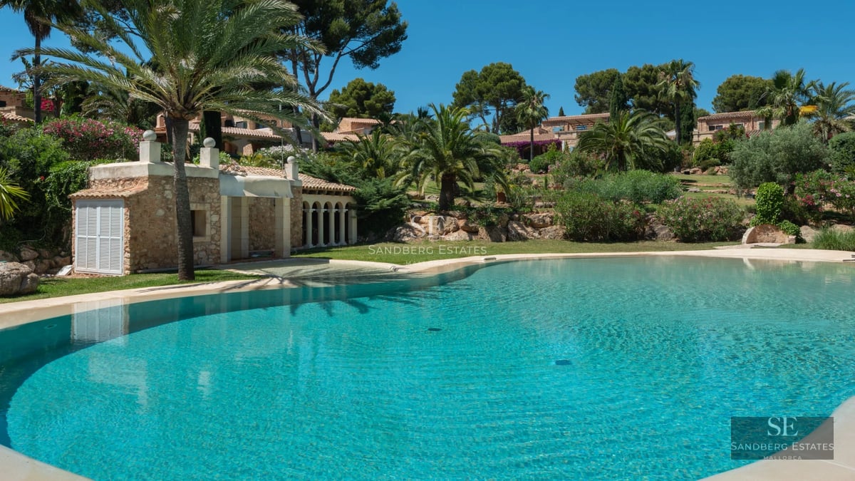 Exterior view of a modern villa with pool, large windows, garden, and minimalist architecture. Warm ambient lighting.