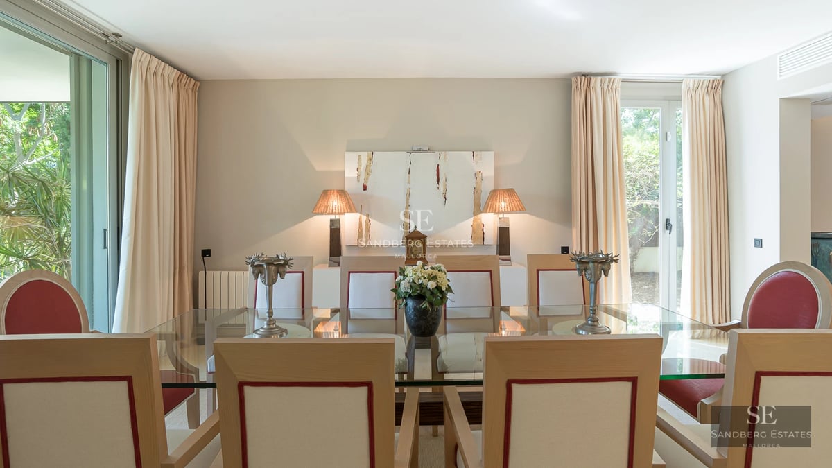 Spacious living room featuring panoramic windows, light wood flooring, modern furniture, and breathtaking ocean views.