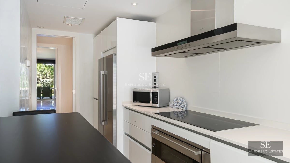 Spacious living room featuring large windows, light wood flooring, and elegant furniture. Panoramic sea views.