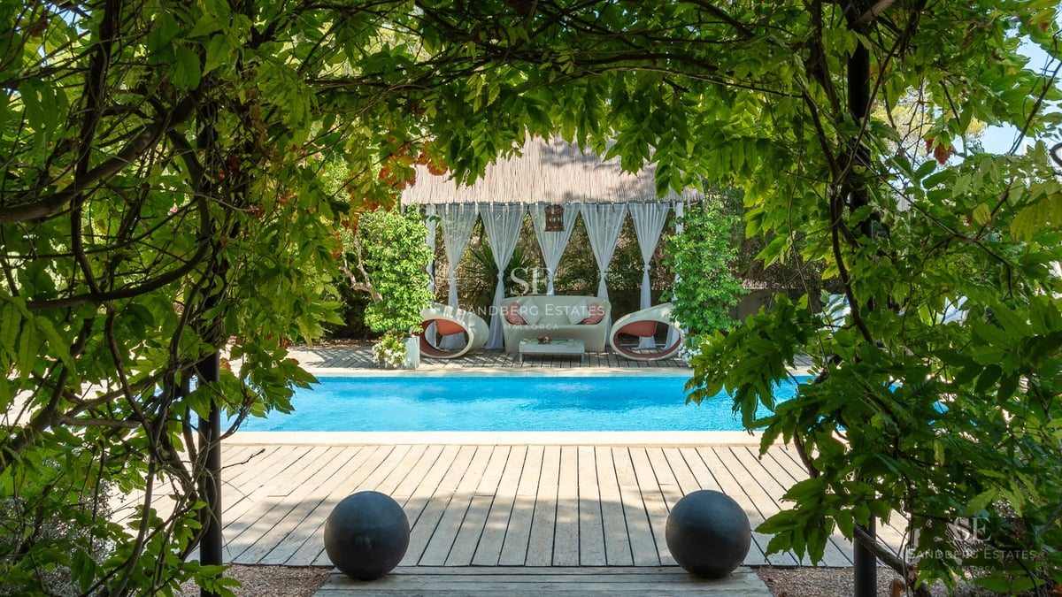 Exterior view of a modern villa with a pool, garden, and terraces. Minimalist architecture with large windows.