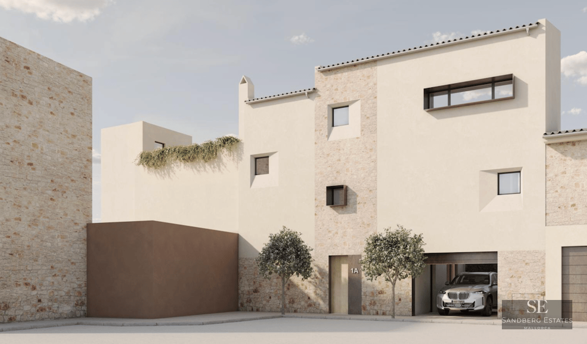 Modern stone and stucco building with minimalist windows and a car in the garage under bright daylight.