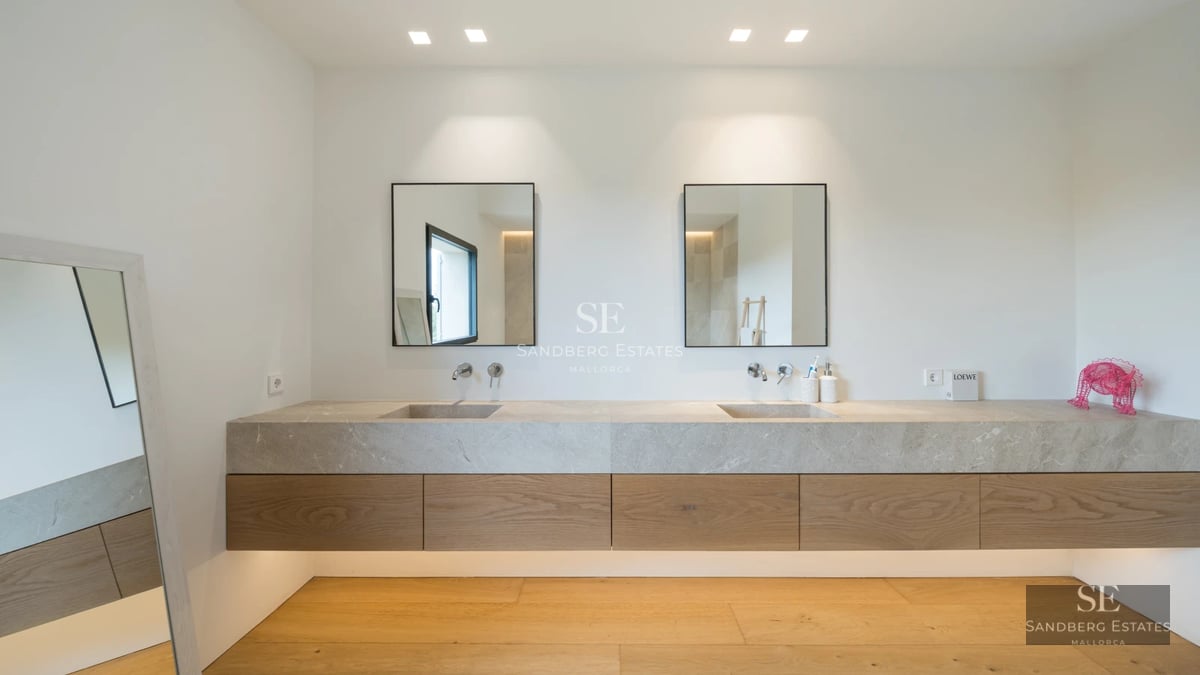 Spacious living room with large windows overlooking the pool. Modern design, natural light, and elegant furniture. Light wood floors and white walls.