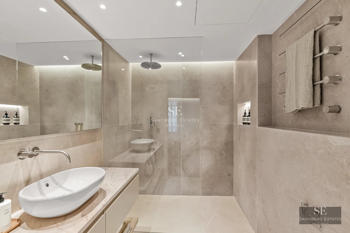 Exterior view of a modern villa featuring an infinity pool, spacious garden, and expansive windows reflecting the sky. Minimalist architecture.