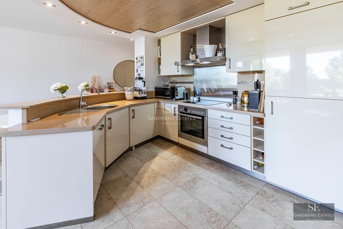 Spacious, bright living room with large windows, light wood floors, modern fireplace, and contemporary designer furniture. Panoramic views.