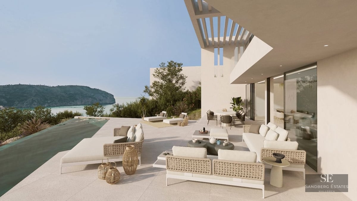 Modern white terrace with infinity pool, stylish outdoor furniture, and panoramic views of a Mediterranean bay.