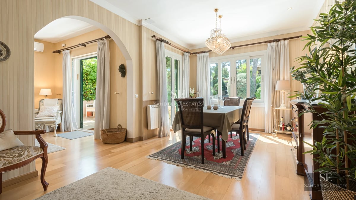 Exterior view of a modern villa with pool, lush garden, and spacious terraces. Minimalist architecture with large windows.