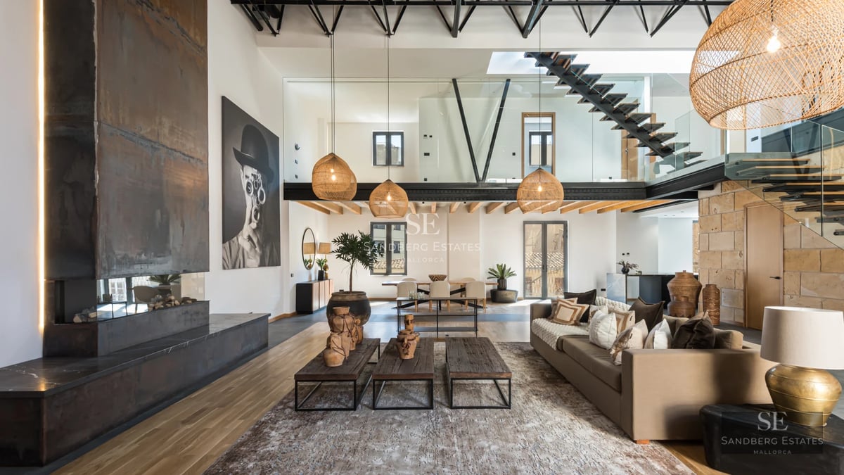 Exterior view of a modern villa with an infinity pool, surrounded by lush greenery and large windows.