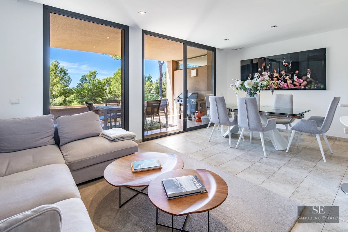 View of a modern villa featuring an infinity pool, lounge chairs, and lush greenery. Minimalist architecture and landscaping.