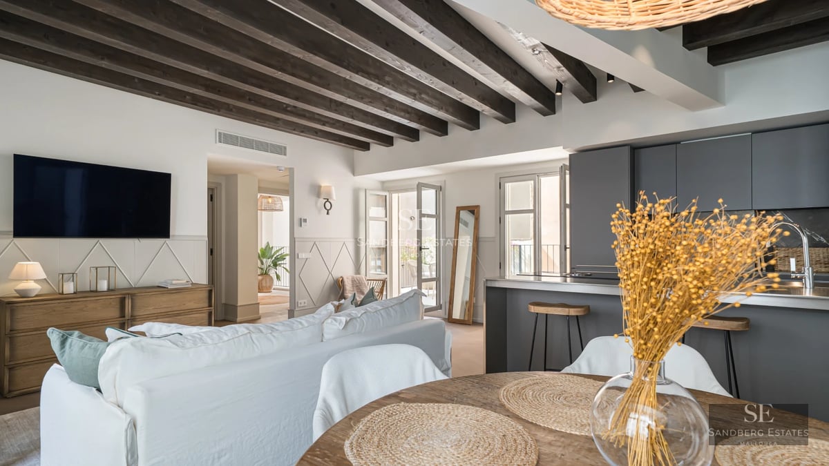 Property view with infinity pool, lush garden, and modern architecture. Warm lighting, sun loungers, and outdoor seating area.