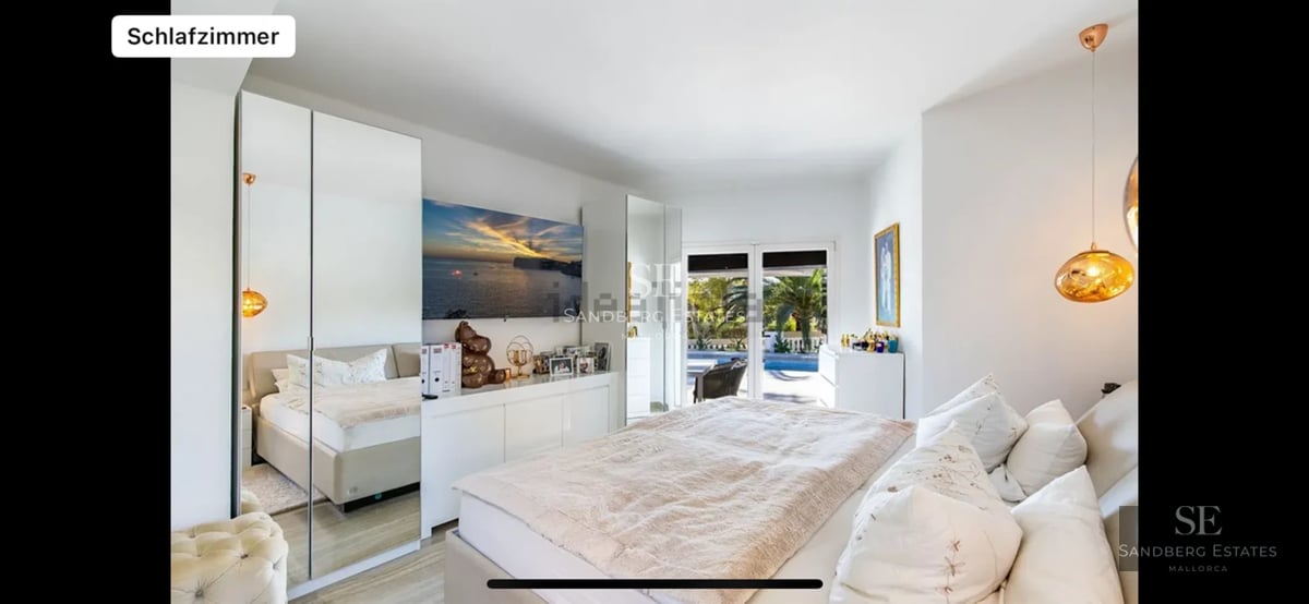 Spacious living room with panoramic windows, light wood flooring, fireplace, and modern design. Natural lighting and garden views.