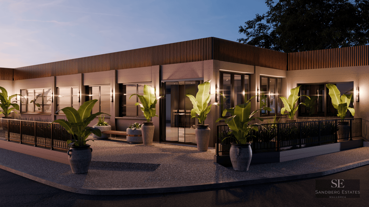 Bâtiment moderne d'un étage au crépuscule avec des lattes de bois, de grandes fenêtres et des plantes tropicales en pot.