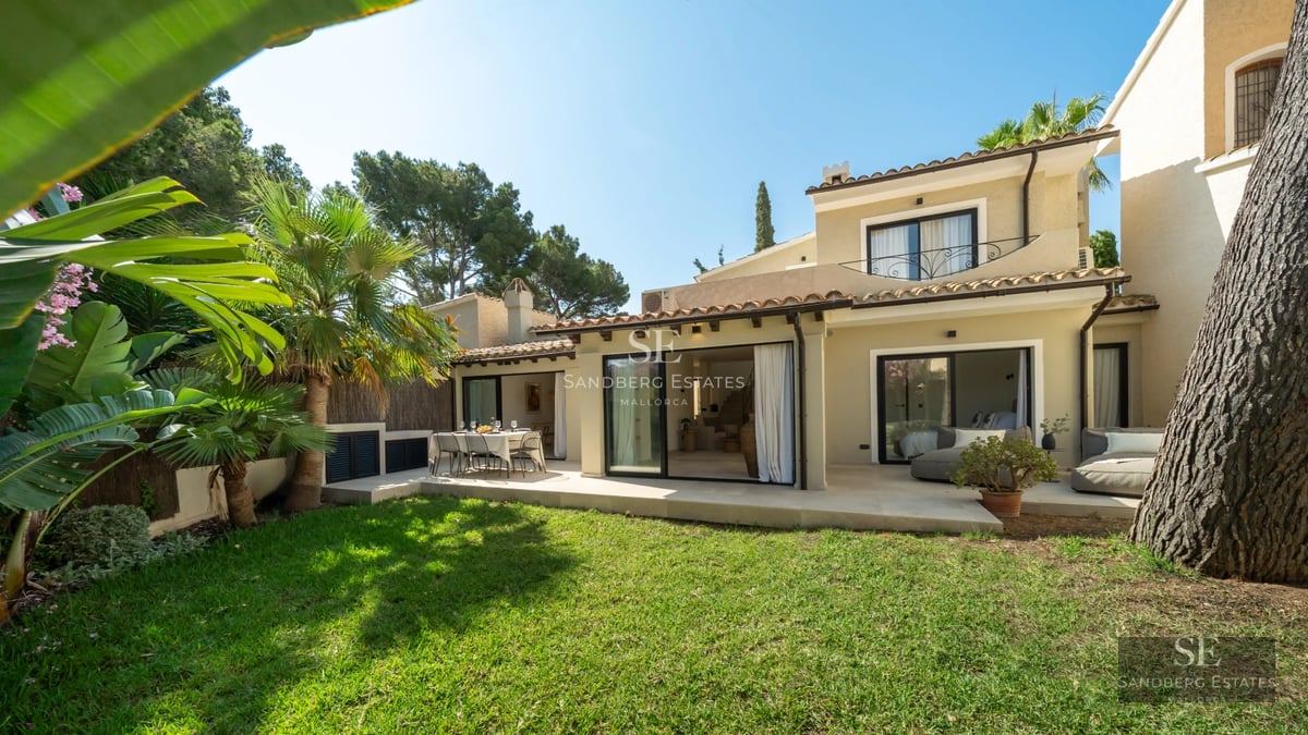 Bright living room with large windows, light wood flooring, white sofas, and panoramic sea views. Modern and elegant design.