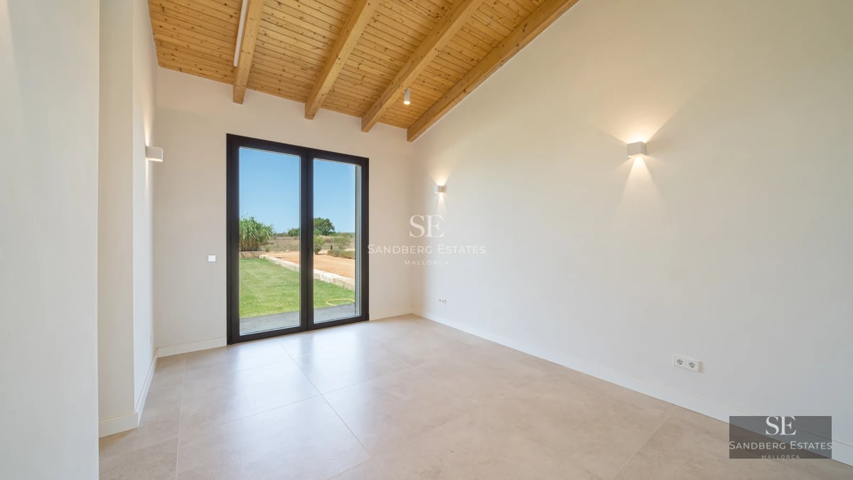 View of modern infinity pool, sun loungers, and minimalist architecture. Large windows reflect sunlight.