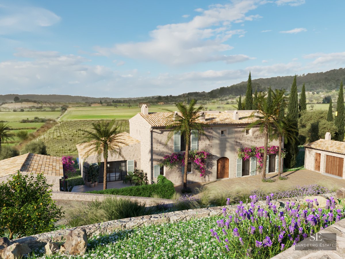 Large rustic stone villa with terracotta roofs, palm trees, and lavender fields under a bright blue sky.