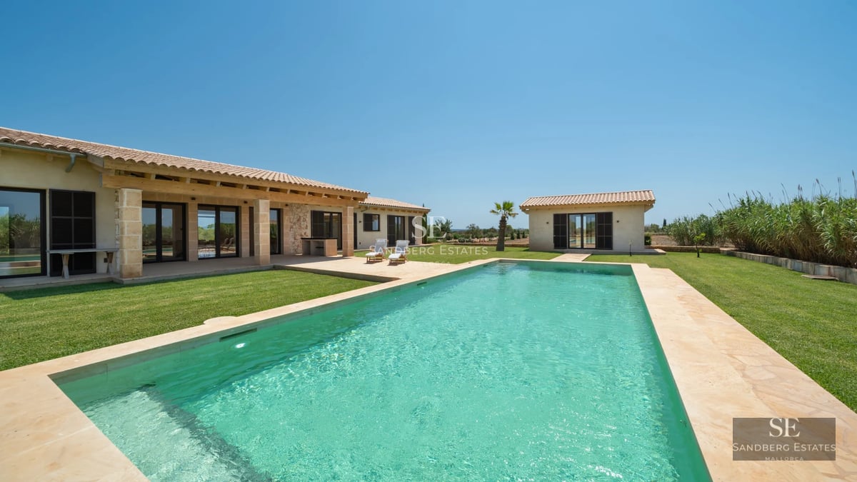 Exterior view of a modern villa with an infinity pool, lush garden and spacious terraces. Minimalist architectural design with high-end finishes.