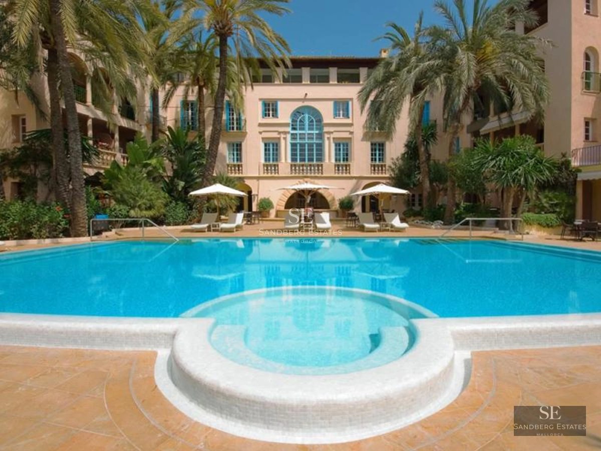 Spacious balcony with panoramic sea views. Modern furniture, glass railing, wooden floor, and retractable awning. Elegant and bright design.