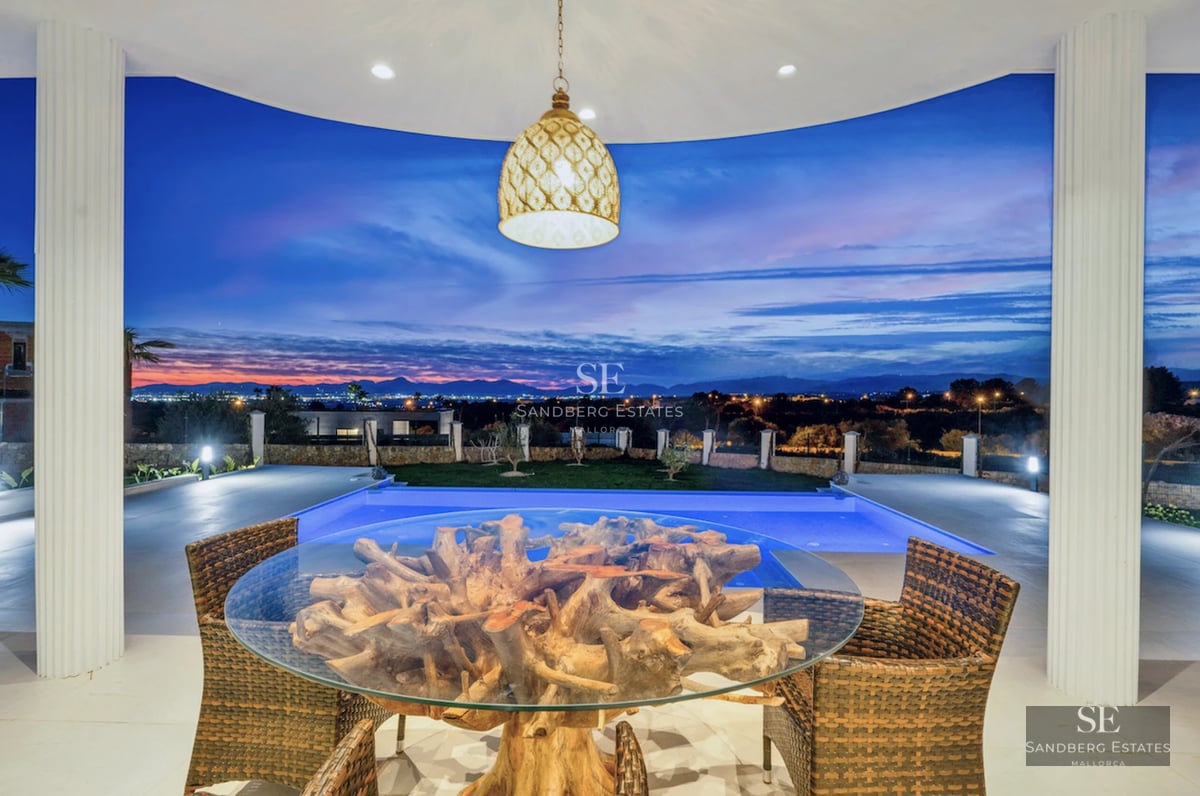 Panoramic view of a modern pool with terrace, sun loungers, and lush vegetation. Minimalist architectural design and luxury finishes.