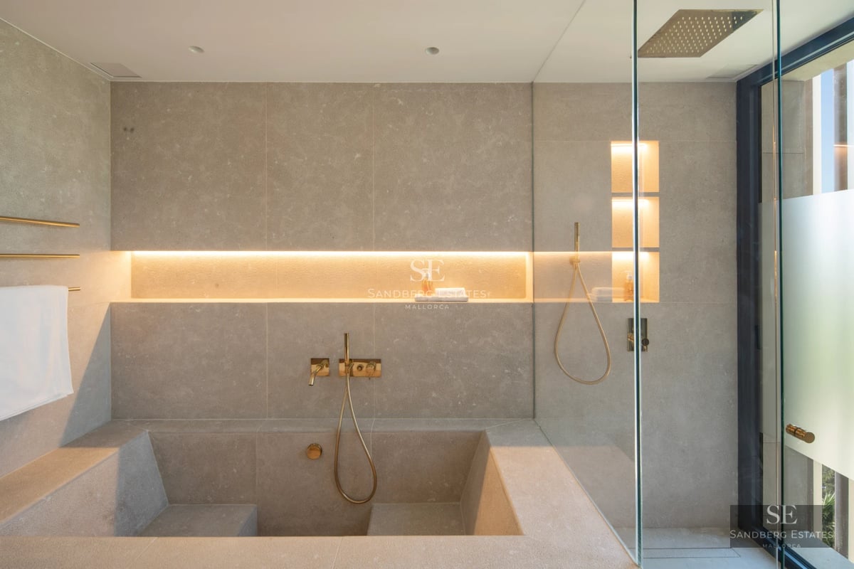 Bright living room with fireplace and balcony access with views. Modern design, wood floors, neutral colors. Large windows.