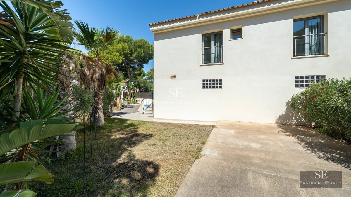 Expansive garden with blue pool, lounge chairs and lush greenery. Modern architecture with large windows and terrace.