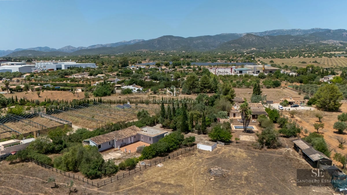 Exterior view of a modern home with a pool. Minimalist design, large windows, and landscaped surroundings. Light facade and clean lines.