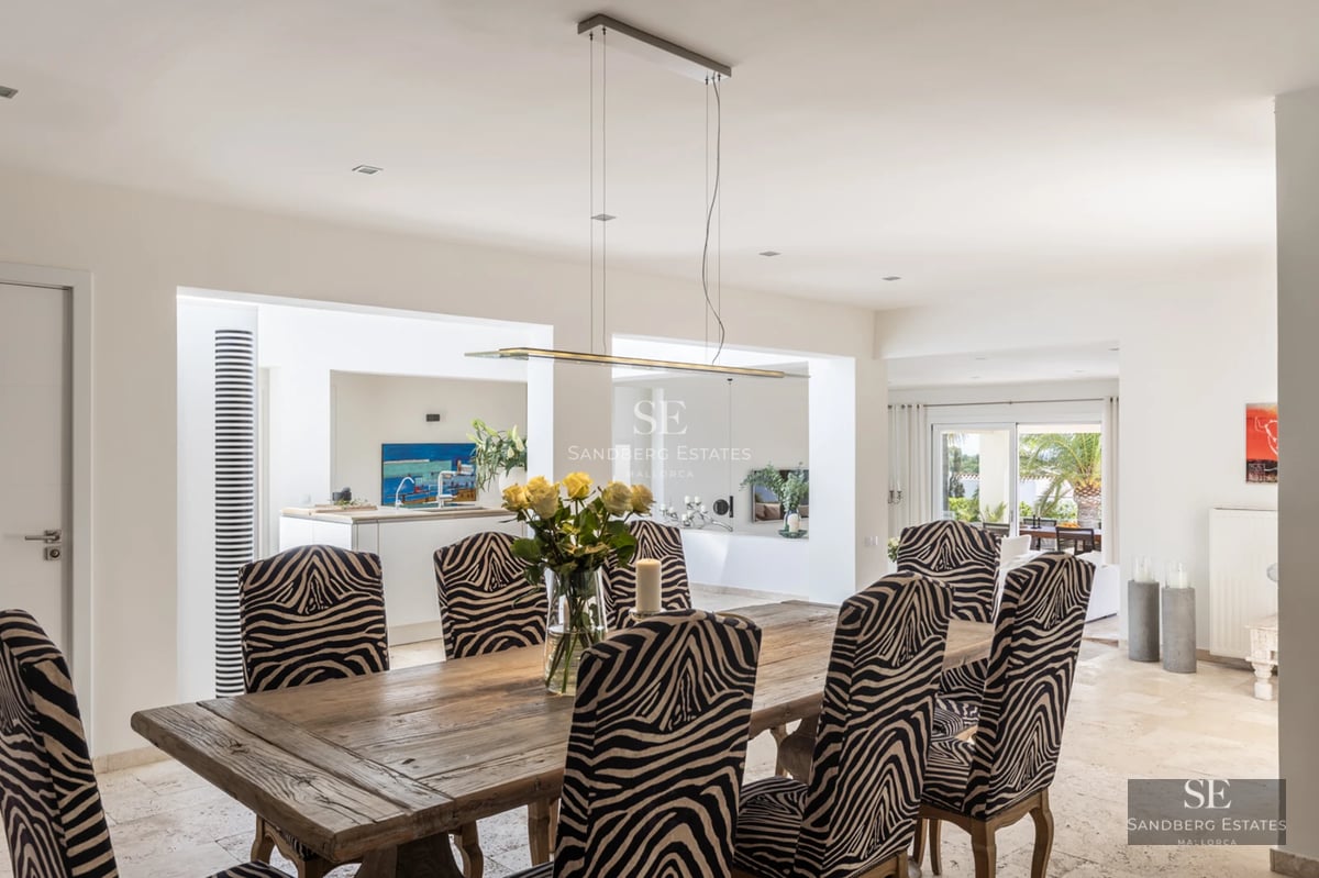 Spacious living room with large windows, light wood floor, modern furniture, and balcony access with panoramic views.