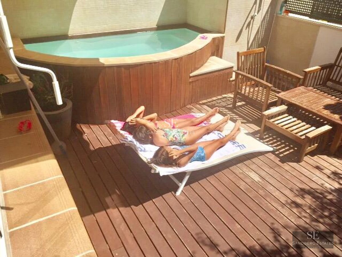 View of a modern villa featuring an infinity pool, lawn, and greenery. Contemporary architecture with large windows and minimalist design.