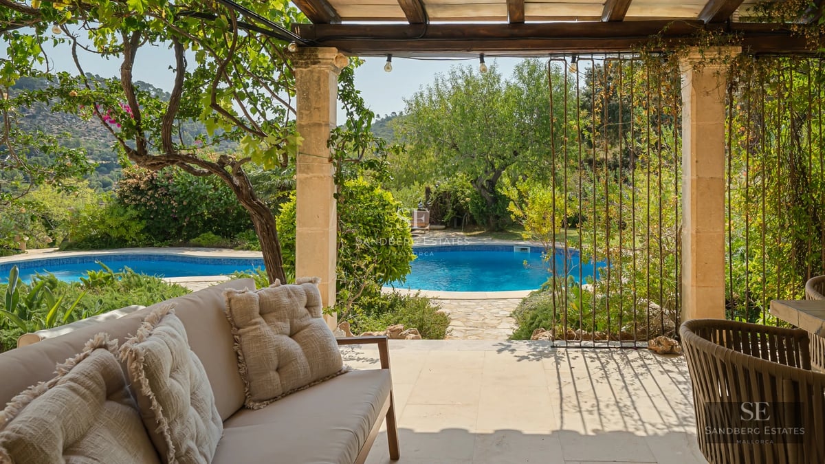 Exterior view of a modern villa featuring an infinity pool, lush gardens, and spacious terraces. Contemporary architectural design.