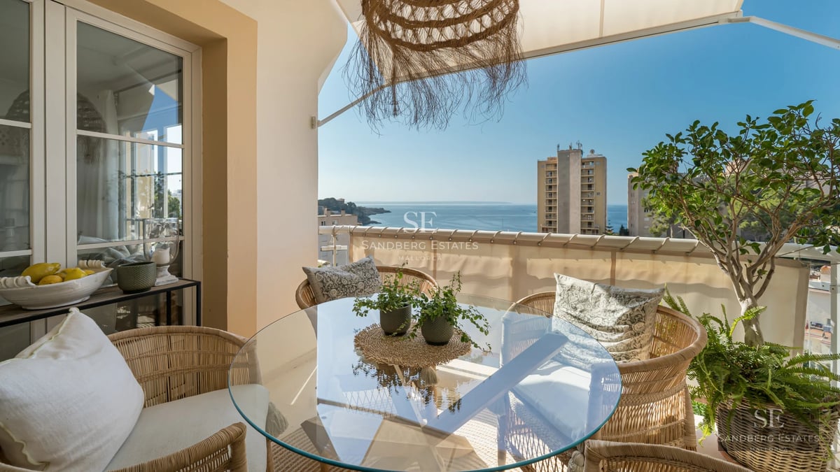 Large infinity pool surrounded by green lawn and sun loungers. Modern architecture with large windows. Luxurious and relaxing outdoor space.