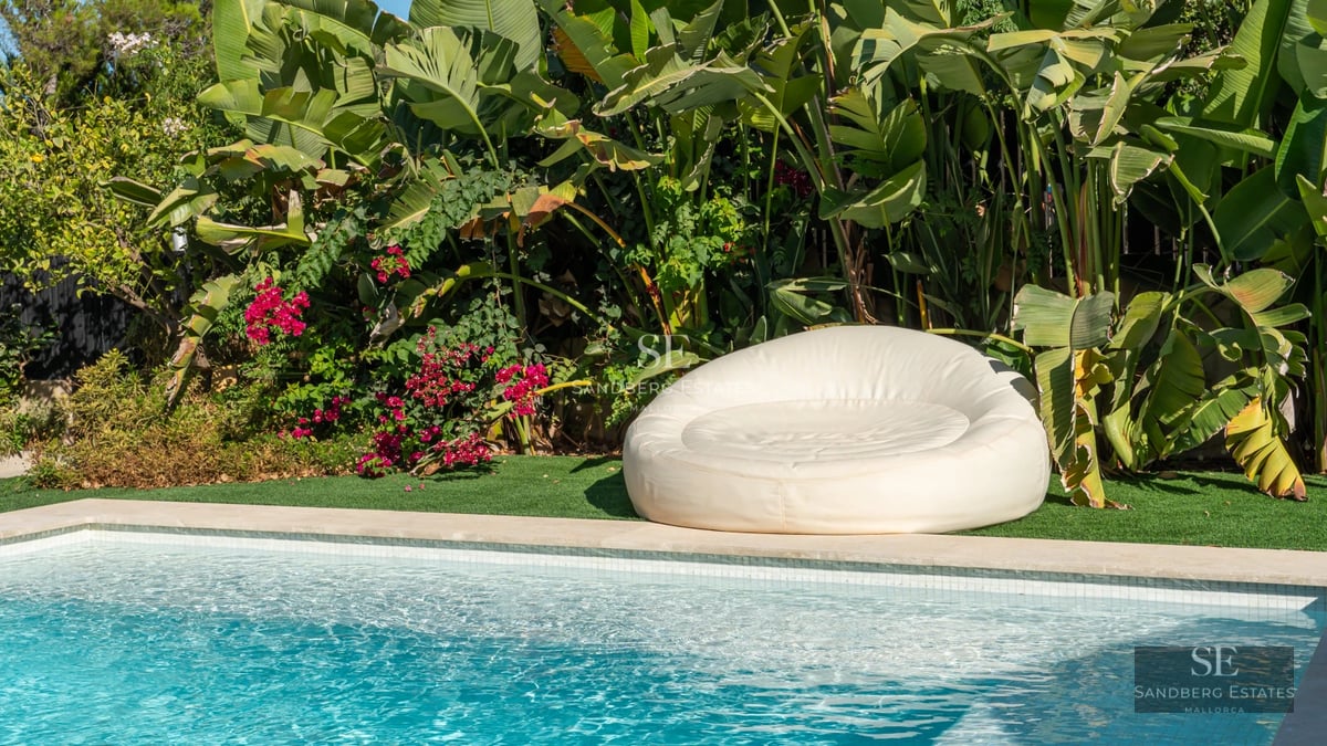 Spacious living room with floor-to-ceiling windows, modern pool with sun loungers. Elegant design and natural light. Ideal for relaxation.